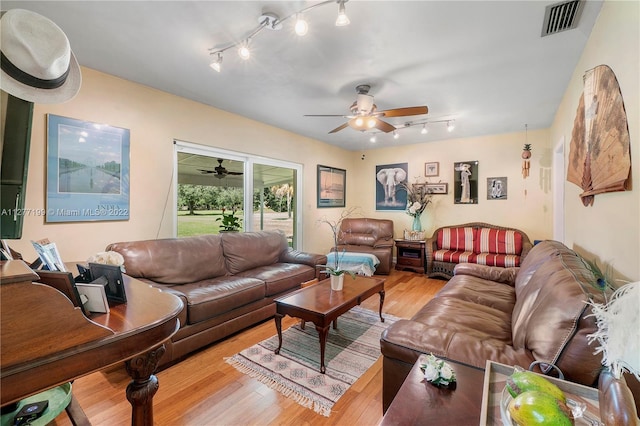 living room with light hardwood / wood-style floors, ceiling fan, and rail lighting