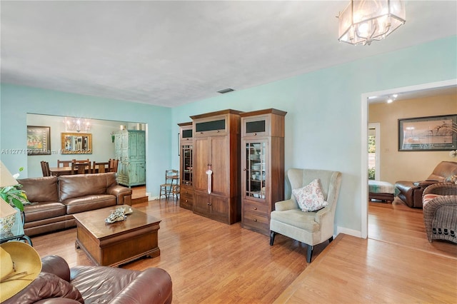 living room featuring a notable chandelier and light hardwood / wood-style flooring