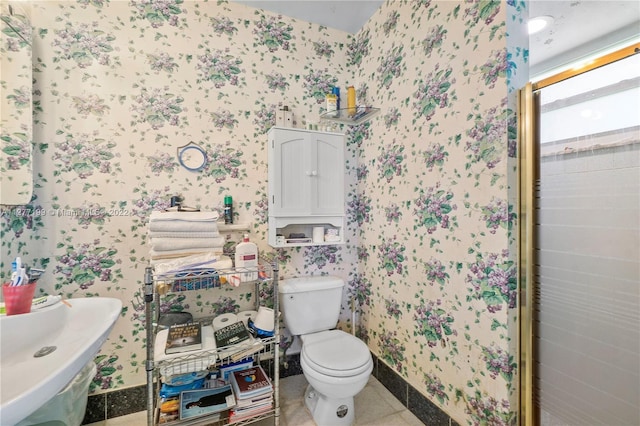 bathroom featuring toilet, tile flooring, tile walls, and sink