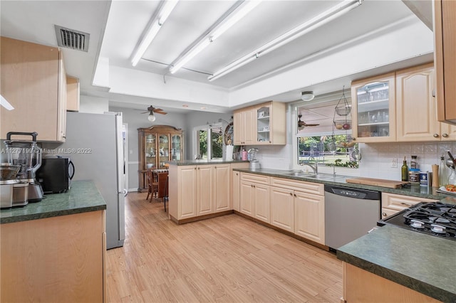 kitchen featuring kitchen peninsula, backsplash, ceiling fan, light hardwood / wood-style floors, and dishwasher