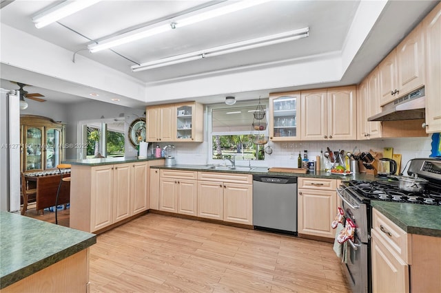 kitchen featuring kitchen peninsula, backsplash, ceiling fan, appliances with stainless steel finishes, and light brown cabinets