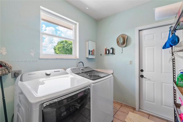 laundry area featuring light tile flooring, electric dryer hookup, and washing machine and dryer