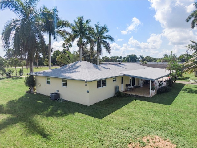 back of house featuring a yard, central air condition unit, and a patio