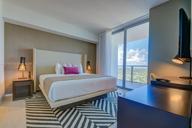 bedroom featuring floor to ceiling windows, access to outside, and light wood-type flooring