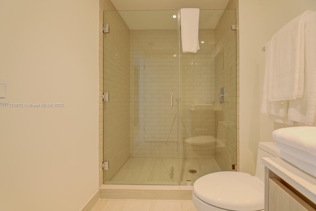 bathroom with toilet, tile floors, a shower with shower door, and vanity