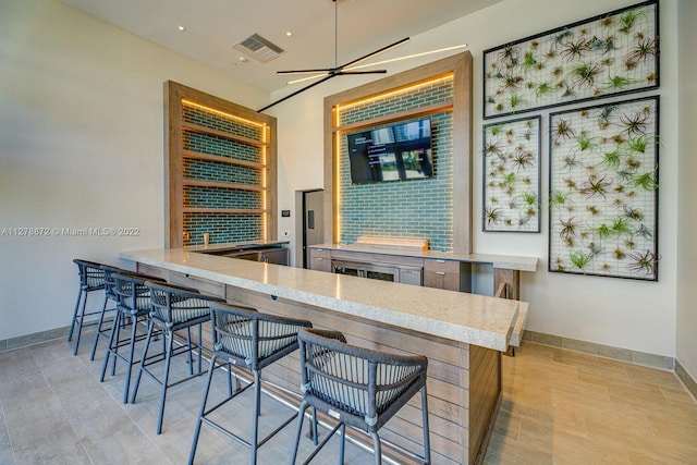 bar with light tile floors and ceiling fan