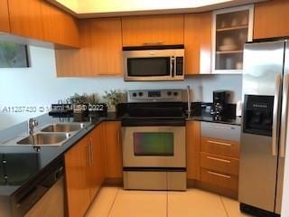 kitchen with light tile floors, appliances with stainless steel finishes, and sink