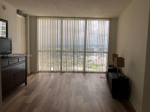 living room with floor to ceiling windows, a textured ceiling, and wood-type flooring