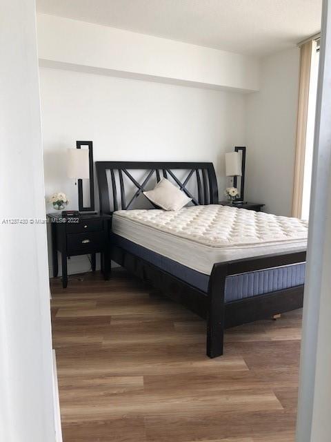 bedroom with dark hardwood / wood-style flooring