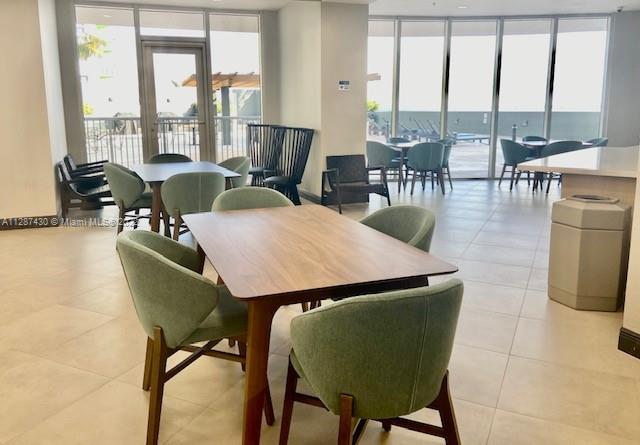 tiled dining space featuring plenty of natural light and a water view