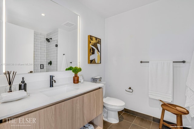 bathroom featuring tile patterned floors, vanity, toilet, and a shower with shower door