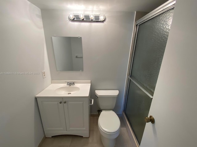 bathroom with toilet, tile floors, and vanity