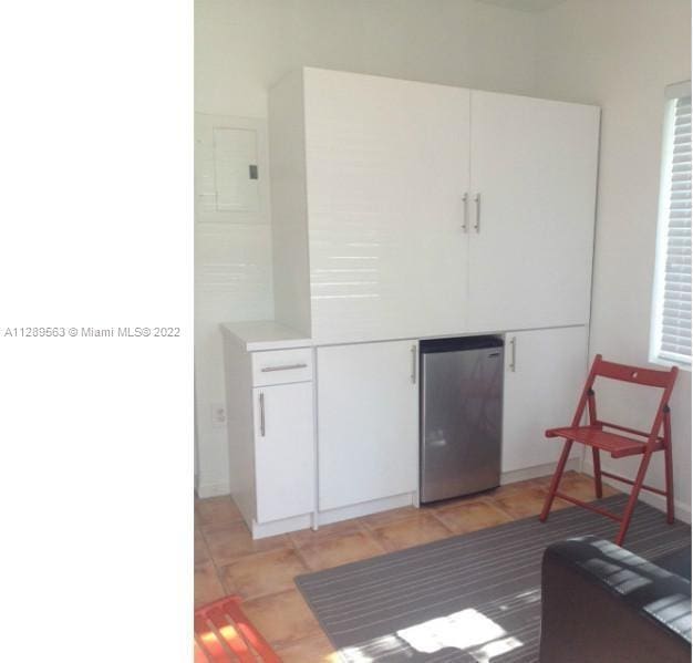 kitchen featuring white cabinetry and refrigerator