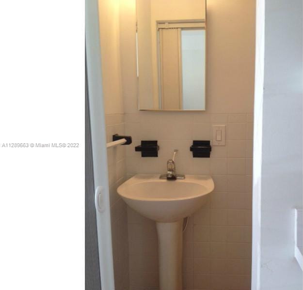 bathroom featuring tile walls and tasteful backsplash