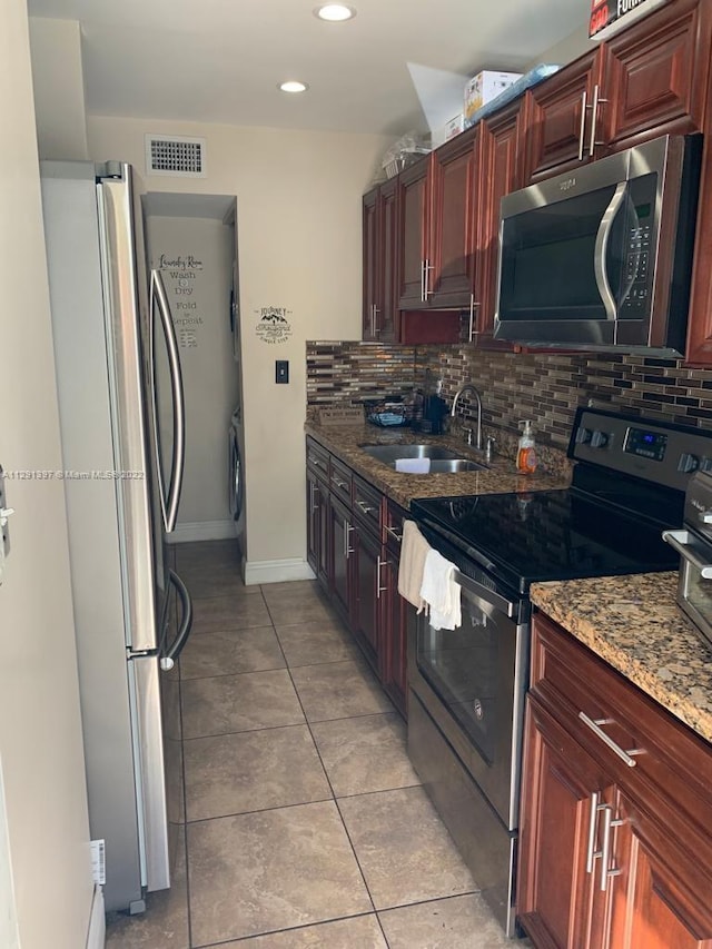 kitchen featuring light tile floors, tasteful backsplash, appliances with stainless steel finishes, sink, and light stone counters