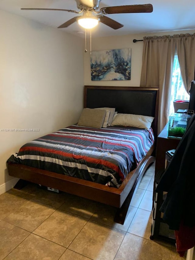 bedroom with ceiling fan and light tile floors