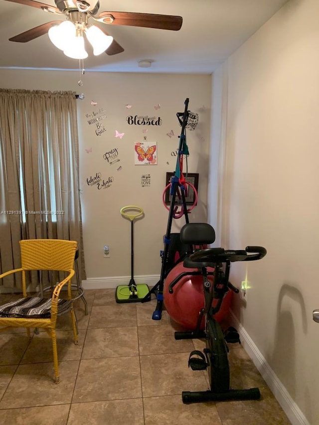 exercise area featuring light tile floors and ceiling fan