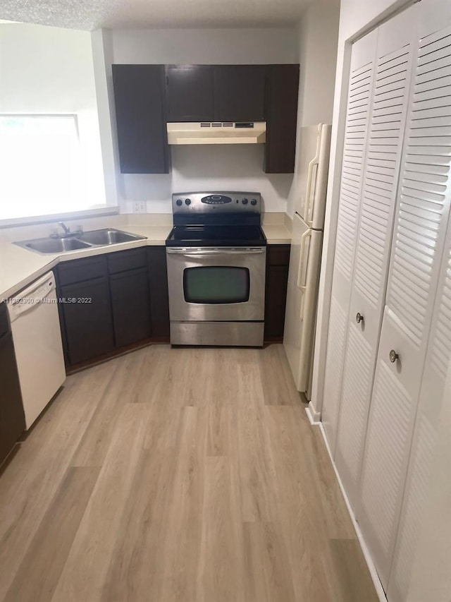 kitchen with light hardwood / wood-style floors, white appliances, and sink