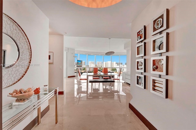 corridor featuring expansive windows and light tile floors