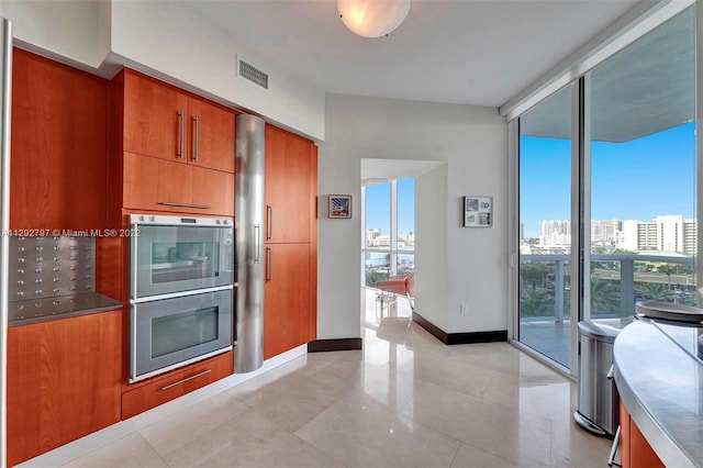 kitchen with light tile floors, double oven, and a wall of windows