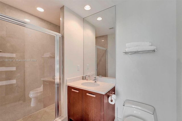 bathroom featuring an enclosed shower, oversized vanity, and toilet