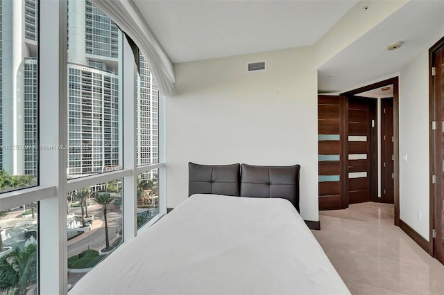 bedroom with multiple windows and light tile flooring