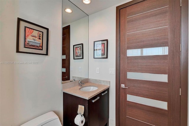 bathroom featuring toilet and vanity with extensive cabinet space