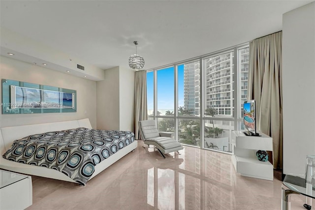 bedroom featuring a chandelier and a wall of windows