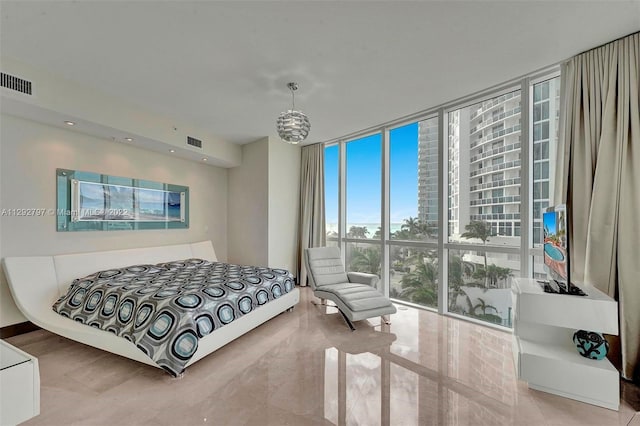 tiled bedroom featuring a chandelier and a wall of windows