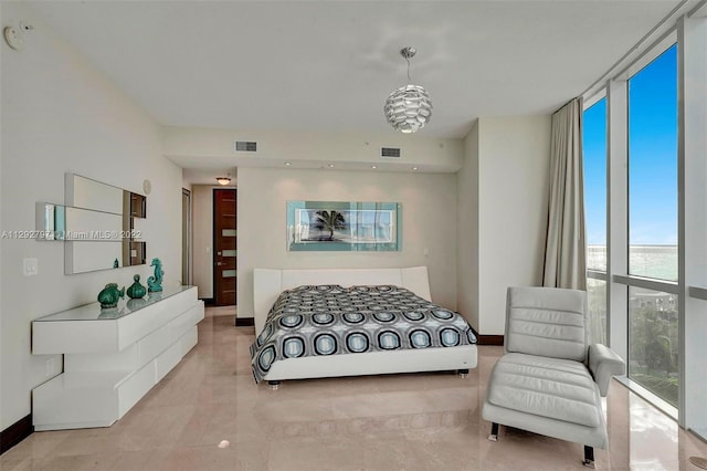 bedroom featuring light tile floors, expansive windows, a chandelier, and a water view