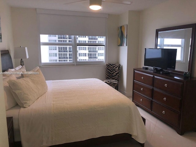 tiled bedroom featuring ceiling fan and multiple windows