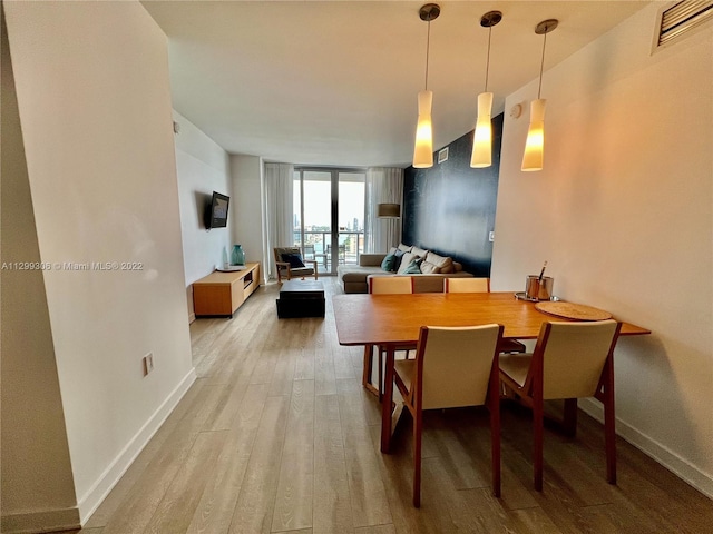 dining room with floor to ceiling windows and wood-type flooring