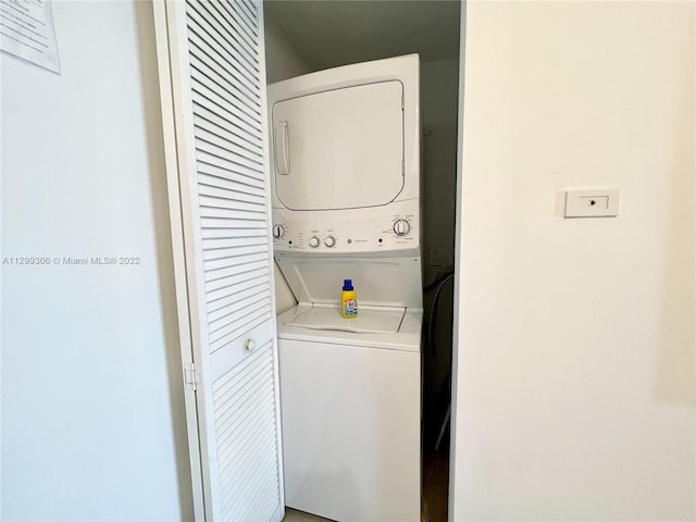 clothes washing area featuring stacked washer and clothes dryer