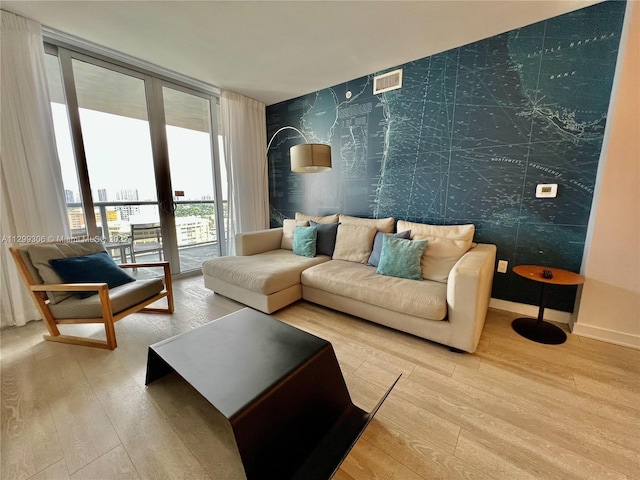 living room featuring french doors, expansive windows, and light hardwood / wood-style flooring