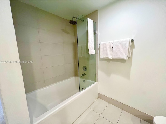 bathroom with toilet, tile floors, and tiled shower / bath