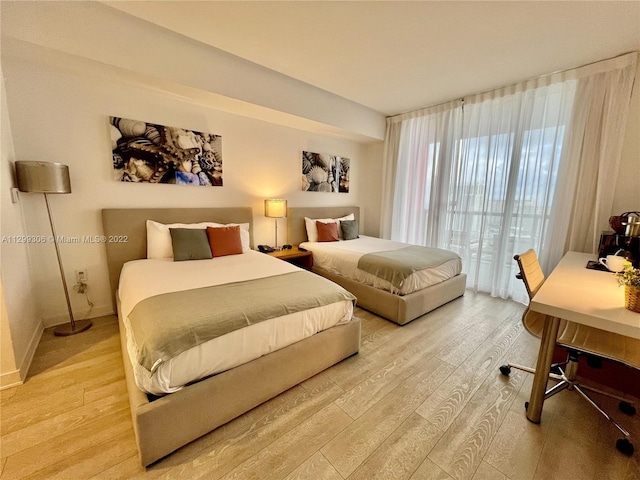 bedroom with access to outside and light wood-type flooring