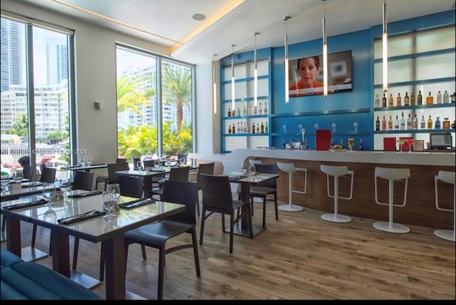 dining area with indoor bar and hardwood / wood-style flooring