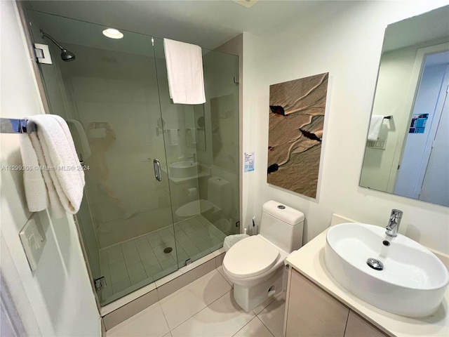 bathroom with toilet, a shower with door, tile floors, and vanity