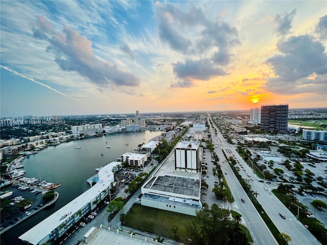 aerial view at dusk featuring a water view