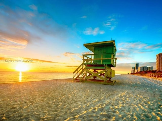 playground at dusk featuring a beach view and a water view