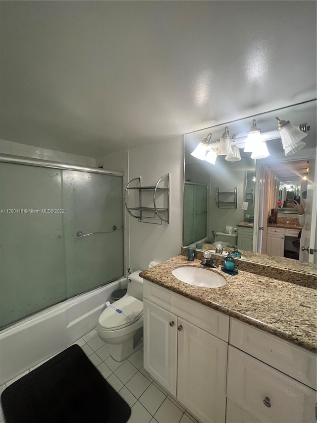 full bathroom featuring combined bath / shower with glass door, tile floors, toilet, and vanity