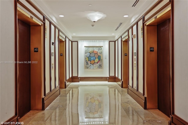 hall with light tile floors and elevator