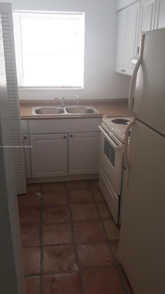 6520 Winfield Blvd Unit 103, Margate, FL 33063 - kitchen with white appliances, white cabinets, and light tile patterned floors