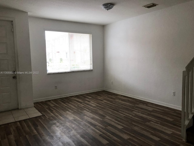 empty room with dark hardwood / wood-style flooring