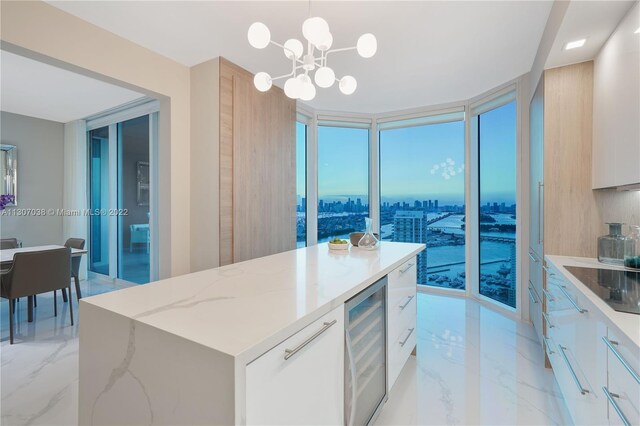 kitchen with pendant lighting, light tile floors, white cabinets, wine cooler, and an inviting chandelier