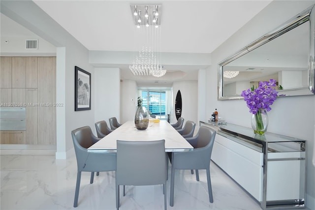 dining space with light tile floors and an inviting chandelier