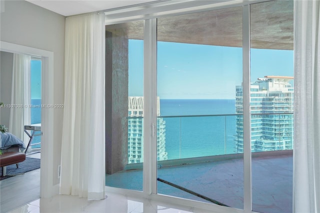 entryway featuring a water view and light tile floors