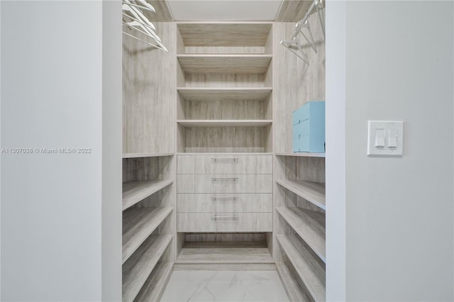 walk in closet with light tile flooring