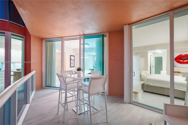 dining space featuring floor to ceiling windows and light hardwood / wood-style flooring