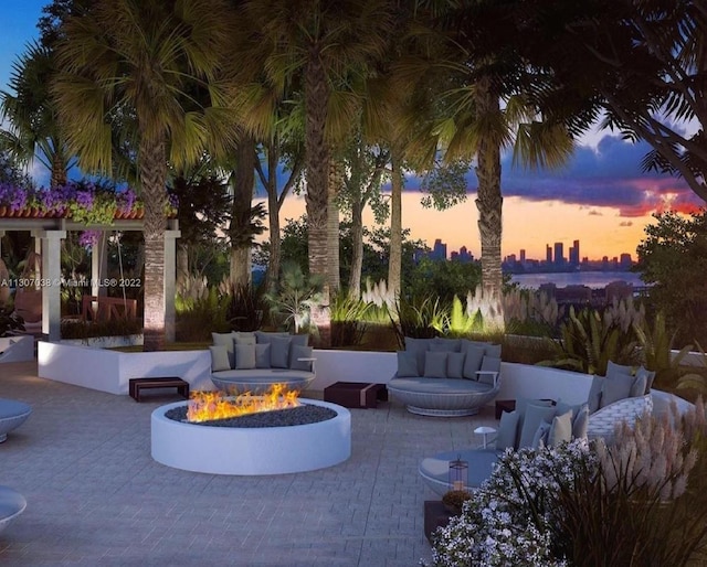 patio terrace at dusk featuring an outdoor living space with a fire pit